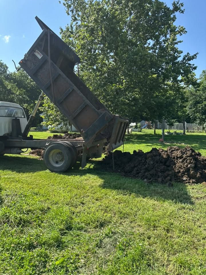 Topsoil delivery by Precision Land & Dig LLC in Adrian, Missouri Dump truck delivering topsoil for excavating contractor Adrian, MO